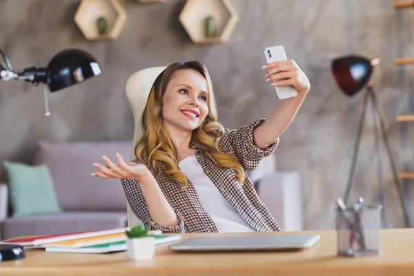 Photo de mignonne charmante jeune femme porter chemise à carreaux table assise tache selfie dispositif moderne à l'intérieur chambre maison maison — Photo