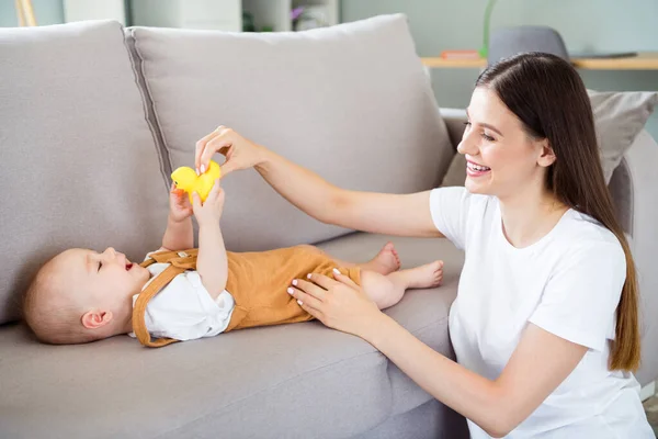 Çekici Dikkatli Bir Kızın Portresi Bebek Emzirirken Kanepenin Üzerinde Oyuncaklarla — Stok fotoğraf