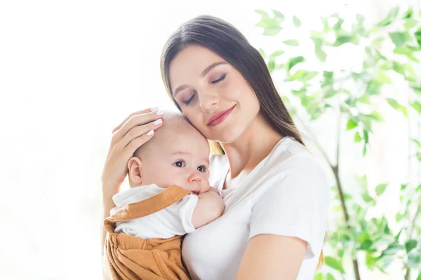 照片上快乐而放松的母亲漂亮的女士抱着小宝宝抱着小宝宝抱着白衬衫回家 — 图库照片
