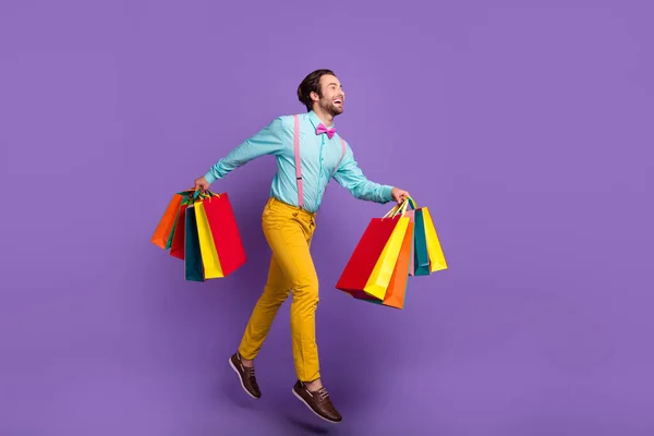 全长尺寸的照片 一个清凉的千禧年时尚的家伙跑与袋穿领带吊带衬衫裤子鞋袜孤立在紫色背景 — 图库照片