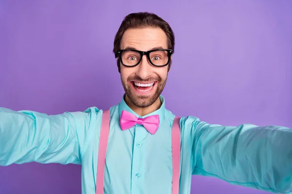 Фото тисячолітнього хлопця брюнетки хлопець робити селфі носити краватку підтяжки сині сорочки окуляри ізольовані на фіолетовому фоні — стокове фото