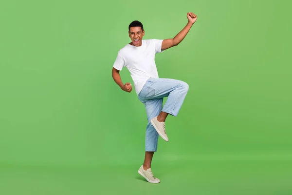 Full body profile side photo of young african man celebrate victory fists hands isolated over green color background.