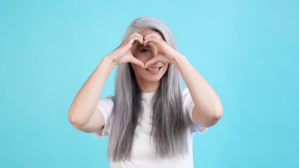 Positive lady make heart fingers see husband isolated blue color background — Stock Video