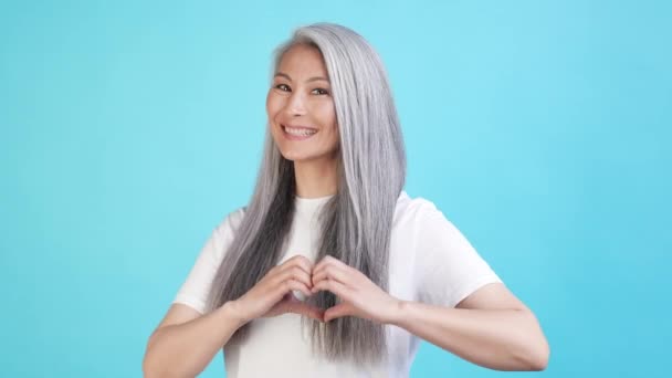 Romantische Dame Gesundheit machen Herz Hand Form isoliert blaue Farbe Hintergrund — Stockvideo