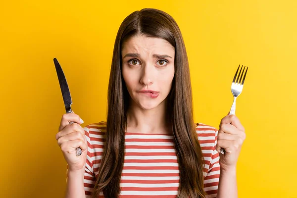 魅力的な女の子空腹の女の子を保持している刃物をかむ唇待っている食事孤立した明るい黄色の色の背景 — ストック写真