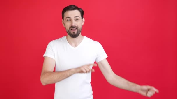 Ecstatic człowiek obecny reklamy podnieść ręce do góry punkt czerwony kolor tło odizolowany — Wideo stockowe