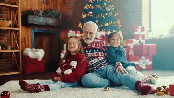 Positieve ontspannen familie vergadering knuffelen zitten comfortabele vloer meisje omarmen huidige doos — Stockvideo