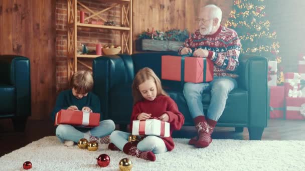 Nieuwsgierige familie ontvangen levering cadeautjes probeer uitpakken doos — Stockvideo