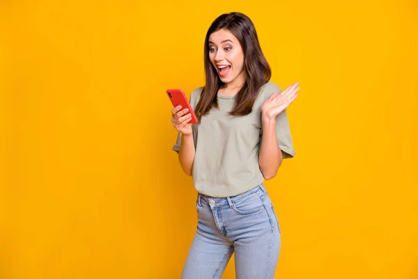 照片中惊喜交集的年轻女子拿着手机 用鲜亮的黄色背景进行广告销售 — 图库照片