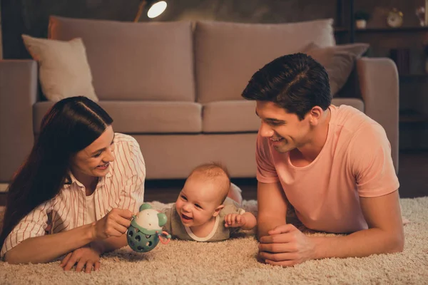 全家人欢欢喜喜地躺在地毯上与婴儿在室内玩耍的画像 — 图库照片