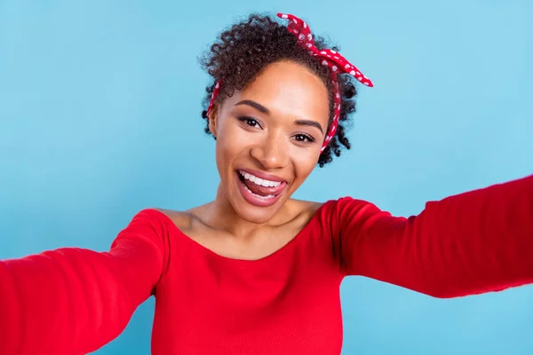 Photo of sweet excited afro girl wear off-shoulders red shirt recording self video licking lips smiling isolated blue color background.