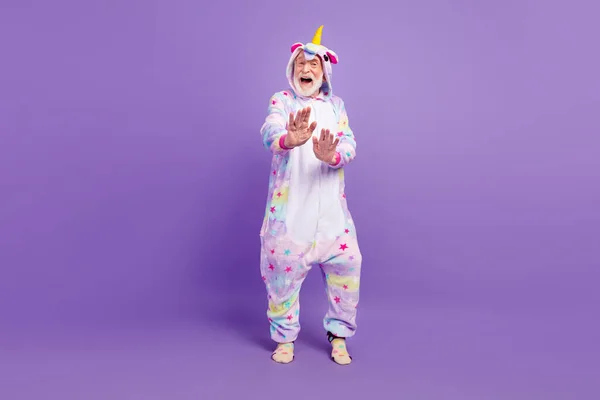 Foto de homem bonito animado pensioner unicórnio sleepwear dança sorrindo isolado cor violeta fundo — Fotografia de Stock
