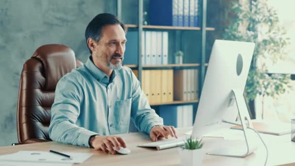 Bearded volwassen werknemer zitten bureau typen jaarlijks financieel verslag — Stockvideo