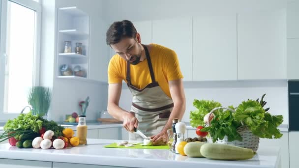Koki pria berjenggot melakukan pemotong sayuran aliran online blog di dapur — Stok Video