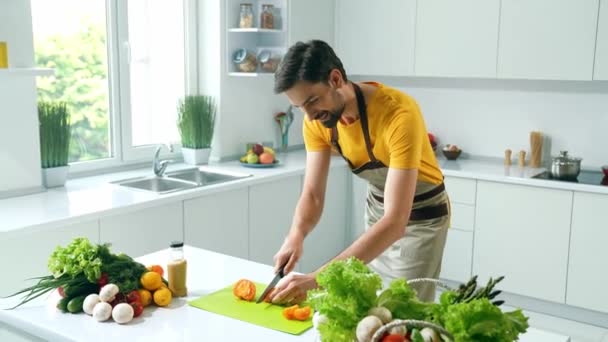 Bearded gourmet guy stream online vegan workshop recipe cut tomato in kitchen — Stock Video