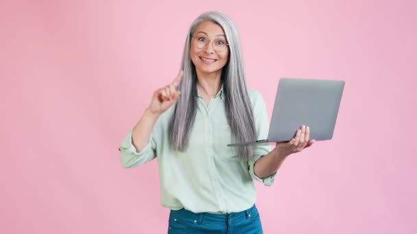 Mediana edad lady point netbook sugieren comprar aislado pastel color fondo — Vídeos de Stock