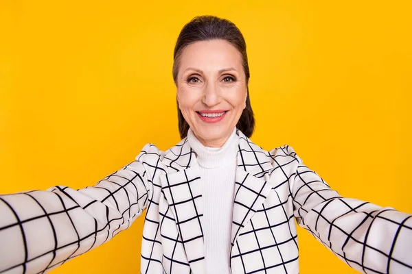 Foto de encantadora senhora alegre fazer selfie radiante sorriso isolado no fundo de cor amarela — Fotografia de Stock