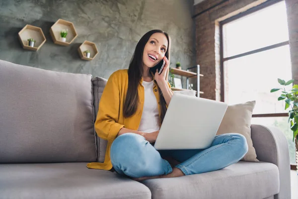 Foto de encantadora mujer madura de ensueño usar camisa amarilla sonriendo comunicando dispositivo moderno interior casa habitación — Foto de Stock