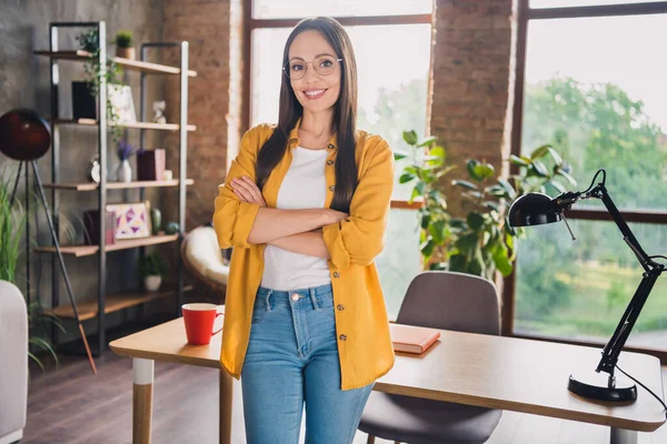 Foto wanita muda yang tampan berbaju kuning kacamata lengan menyeberangi rumah dengan tersenyum di dalam ruangan rumah — Stok Foto