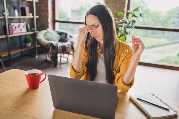 Foto de mujer madura molesta cansada usar gafas de camisa amarilla plazo de trabajo dispositivo moderno interior casa habitación — Foto de Stock