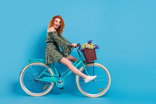 Foto de perfil de comprimento total de doce senhora passeio de bicicleta desgaste vestido tênis isolado no fundo de cor azul — Fotografia de Stock