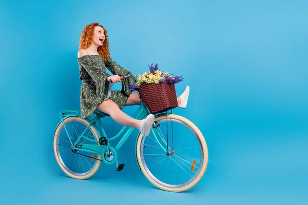 Pełnowymiarowe zdjęcie profilowe imponującej pani jeździć na rowerze nosić trampki sukienka izolowane na niebieskim tle koloru — Zdjęcie stockowe