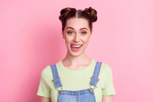 Fénykép vicces flörtölős lány stick-out nyelv nyalás fogak viselnek farmer teljes zöld póló elszigetelt rózsaszín háttér — Stock Fotó