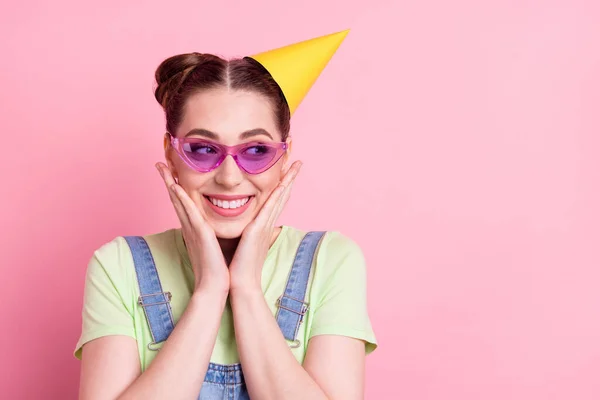 Foto ritratto ragazza in generale occhiali da sole indossa cappuccio giallo alla festa toccando guance isolato colore rosa pastello sfondo — Foto Stock