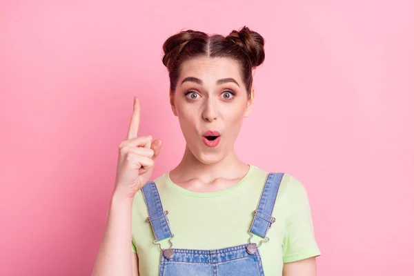 Foto van genie geek meisje hebben idee verhogen vinger open mond slijtage jeans overall groen t-shirt geïsoleerd op roze achtergrond — Stockfoto