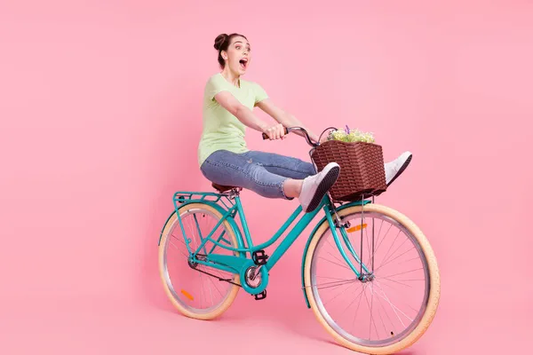 Foto de perfil de senhora enérgica louca motorista descuidado passeio de bicicleta grito desgaste camiseta verde isolado no fundo rosa — Fotografia de Stock