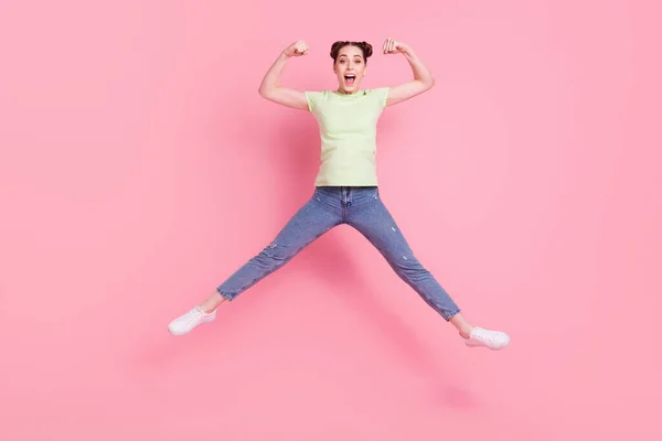 Foto de señora fuerte loco salto mostrar grandes bíceps músculo desgaste camiseta verde aislado sobre fondo rosa —  Fotos de Stock