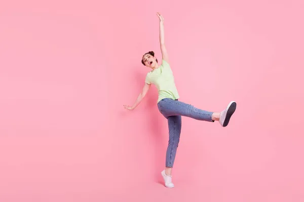 무신경 한 클럽 우먼 춤을 추는 사진 핑크 색 배경에 고립된 녹색 티셔츠를 입은 채 활짝 열려 있는 입을 벌리며 즐거움을 만끽 한다 — 스톡 사진