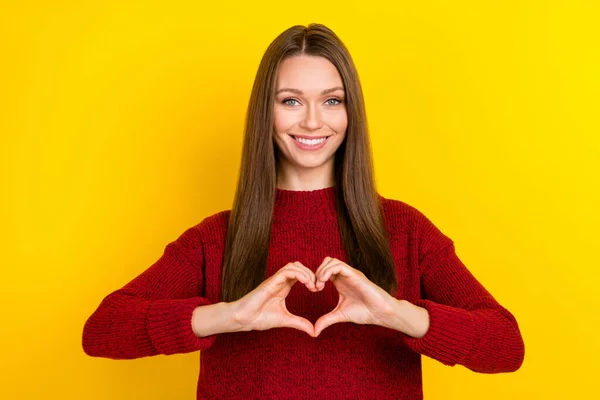 Portrait d'une jolie fille aux cheveux bruns joyeux montrant le symbole du cœur isolé sur fond de couleur jaune vif — Photo