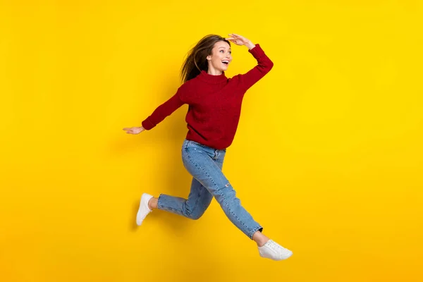 Πλήρες μήκος του σώματος άποψη του μεγέθους ελκυστική κατάπληκτος χαρούμενο κορίτσι άλμα περπάτημα ψάχνοντας ειδήσεις απομονωμένη πάνω από φωτεινό κίτρινο χρώμα φόντο — Φωτογραφία Αρχείου
