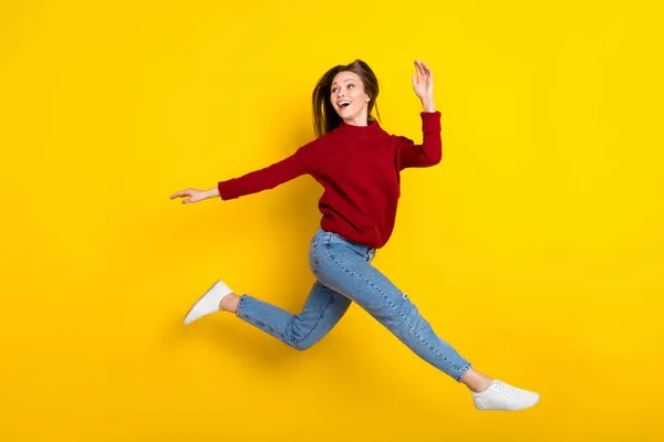 Foto lateral de perfil de longitud completa de la joven mujer emocionada feliz sonrisa positiva saltar curioso mirar espacio vacío aislado sobre fondo de color amarillo —  Fotos de Stock