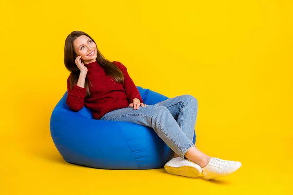 全身型侧面照片年轻女子快乐积极的微笑坐在椅子上蚕豆舒适的梦想空旷的空间隔离在黄色的背景上 — 图库照片