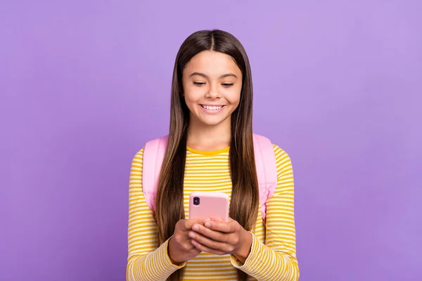 年轻快乐女孩的照片看起来像阅读手机聊天短信，像是在紫色背景上孤立的评论 — 图库照片