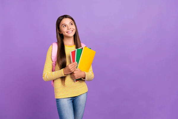 Photo of young dreamy girl hold materials courses look empty space think isolated over purple color background — Stock Photo, Image