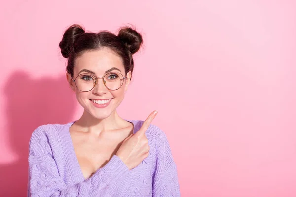 Foto portret van meisje met top knoop kapsel wijzende vinger lege ruimte geïsoleerd op pastel roze kleur achtergrond — Stockfoto