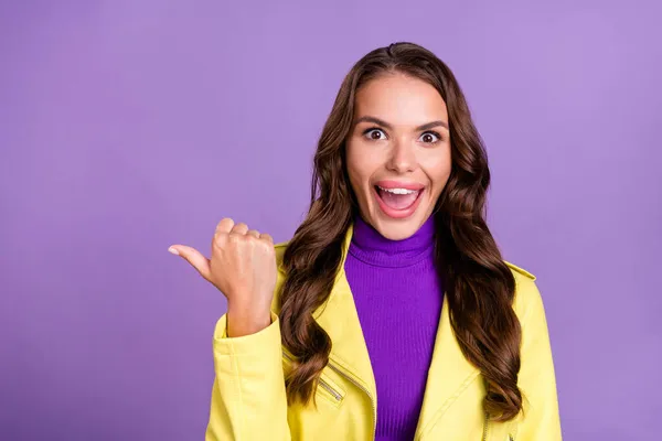 Foto de menina alegre jovem indicar polegar espaço vazio escolher anúncios promocionais isolados sobre fundo cor violeta — Fotografia de Stock