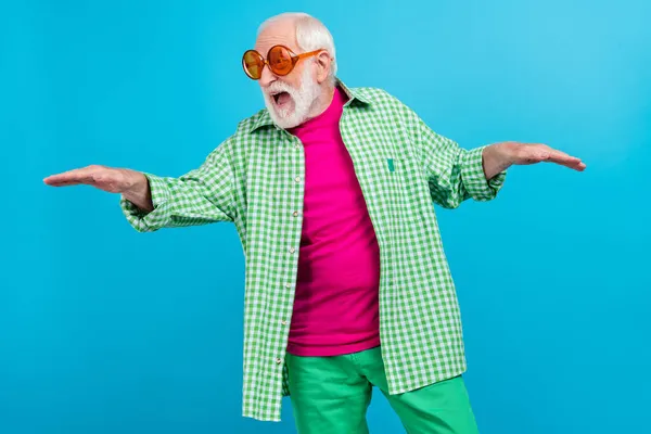 Foto de alegre feliz emocionado anciano danza desgaste gafas de sol vacaciones estado de ánimo aislado sobre fondo de color azul — Foto de Stock