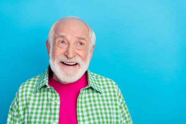Fénykép vidám álmodozó pozitív öreg ember néz üres tér jó ötlet mosoly elszigetelt pasztell kék szín háttér — Stock Fotó