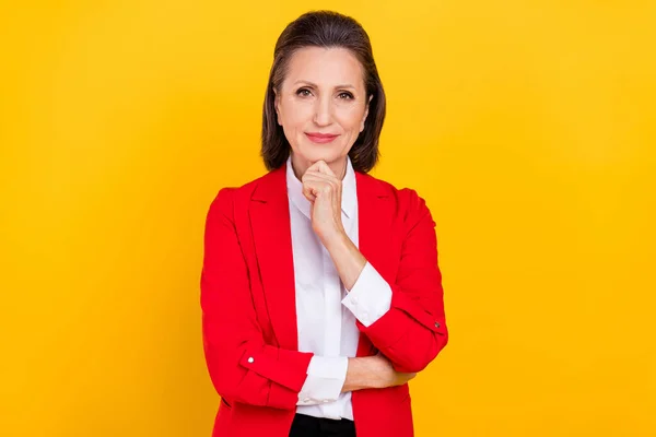 Foto von intelligenten gealterten brünetten Dame Hand Gesicht tragen rote Jacke isoliert auf gelbem Hintergrund — Stockfoto