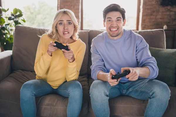 Portrait of attractive worried funky cheery couple playing game having fun at home loft industrial interior indoors — Stock Photo, Image