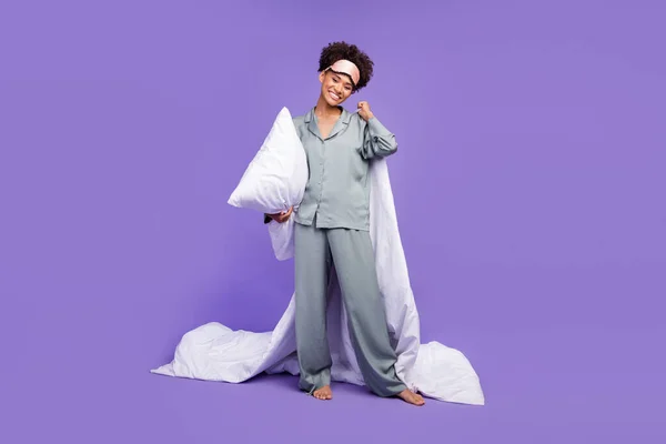 Fénykép fényes édes vicces nő szürke hálóruha gazdaság párna takaró mosolygó elszigetelt ibolya szín háttér — Stock Fotó