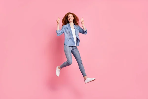 Pełna długość zdjęcie wesoły słodkie młoda kobieta skakać uśmiech zrobić v-signs izolowane na różowy kolor tła — Zdjęcie stockowe