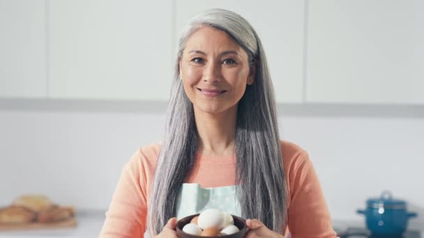 Señora de mediana edad demuestran aves de corral huevos dieta ecológica comer en la cocina — Vídeo de stock