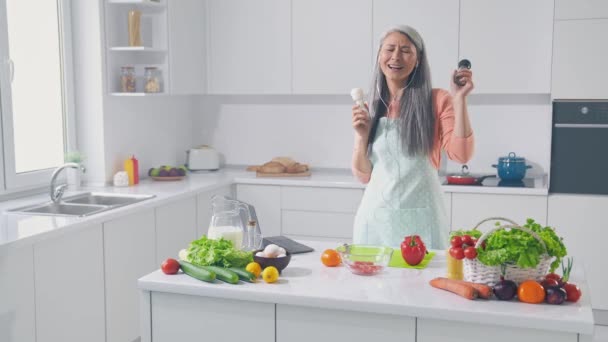 Energetische Dame macht Gericht Lunch Tanz Kräutertopf hören Rock Headset in der Küche — Stockvideo