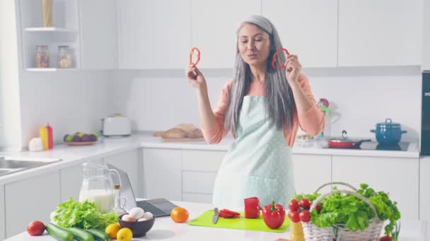 Τρελή κυρία κάνει το δείπνο απώλεια βάρους σαλάτα χορό κόκκινο πιπέρι φέτες πρόσωπο στην κουζίνα — Αρχείο Βίντεο
