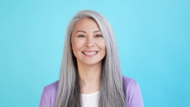 Blij dame portret blik in camera glimlachen geïsoleerd op blauwe kleur achtergrond — Stockvideo